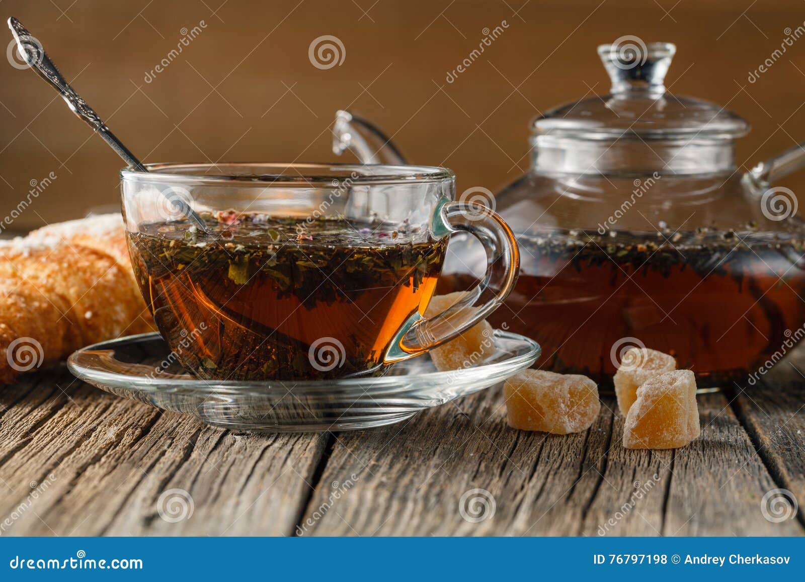 Glass teapot and cup with herbal tea on old wooden table