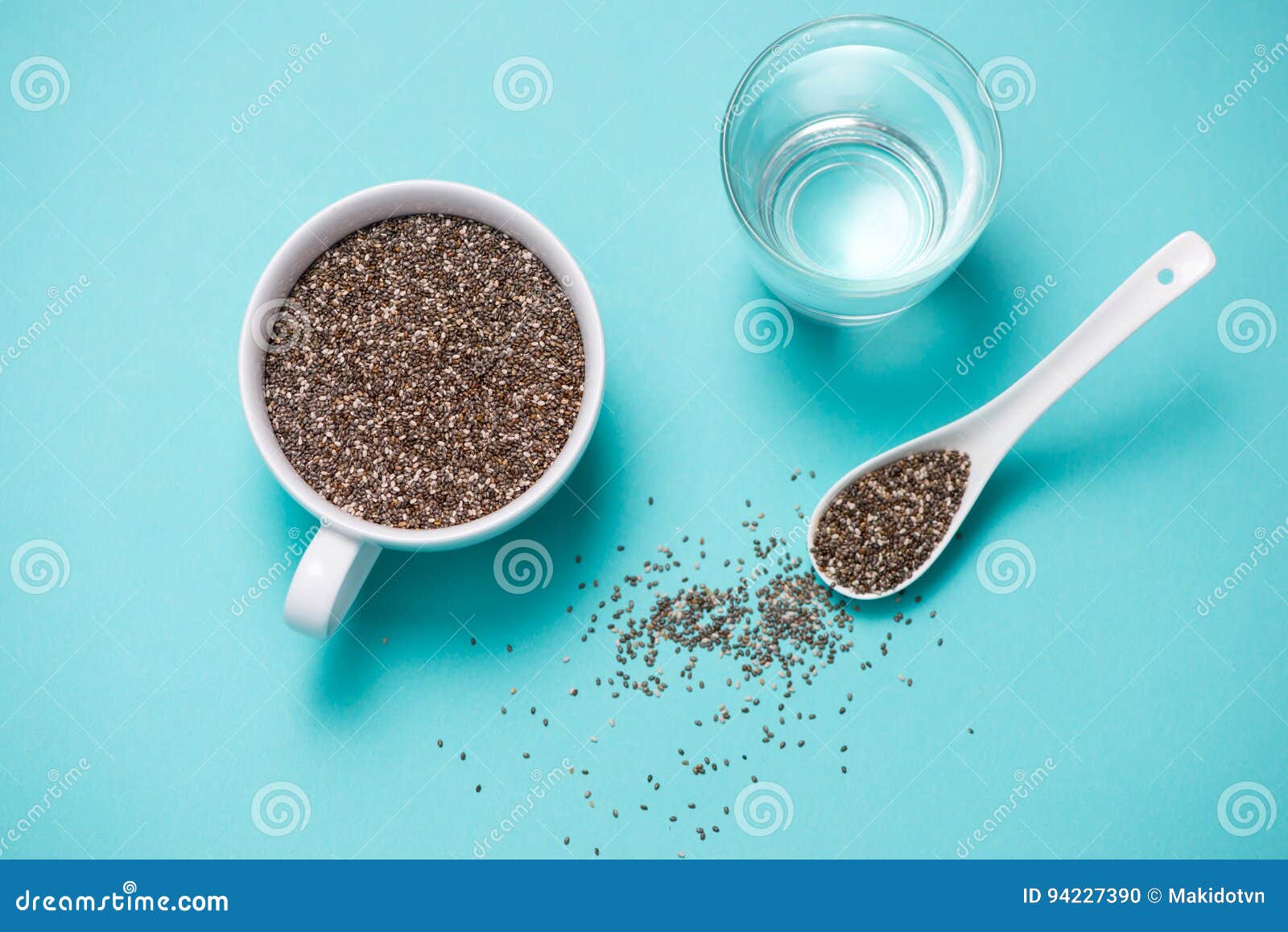 Glass of water with cup of healthy chia seeds and spoon. Text space.