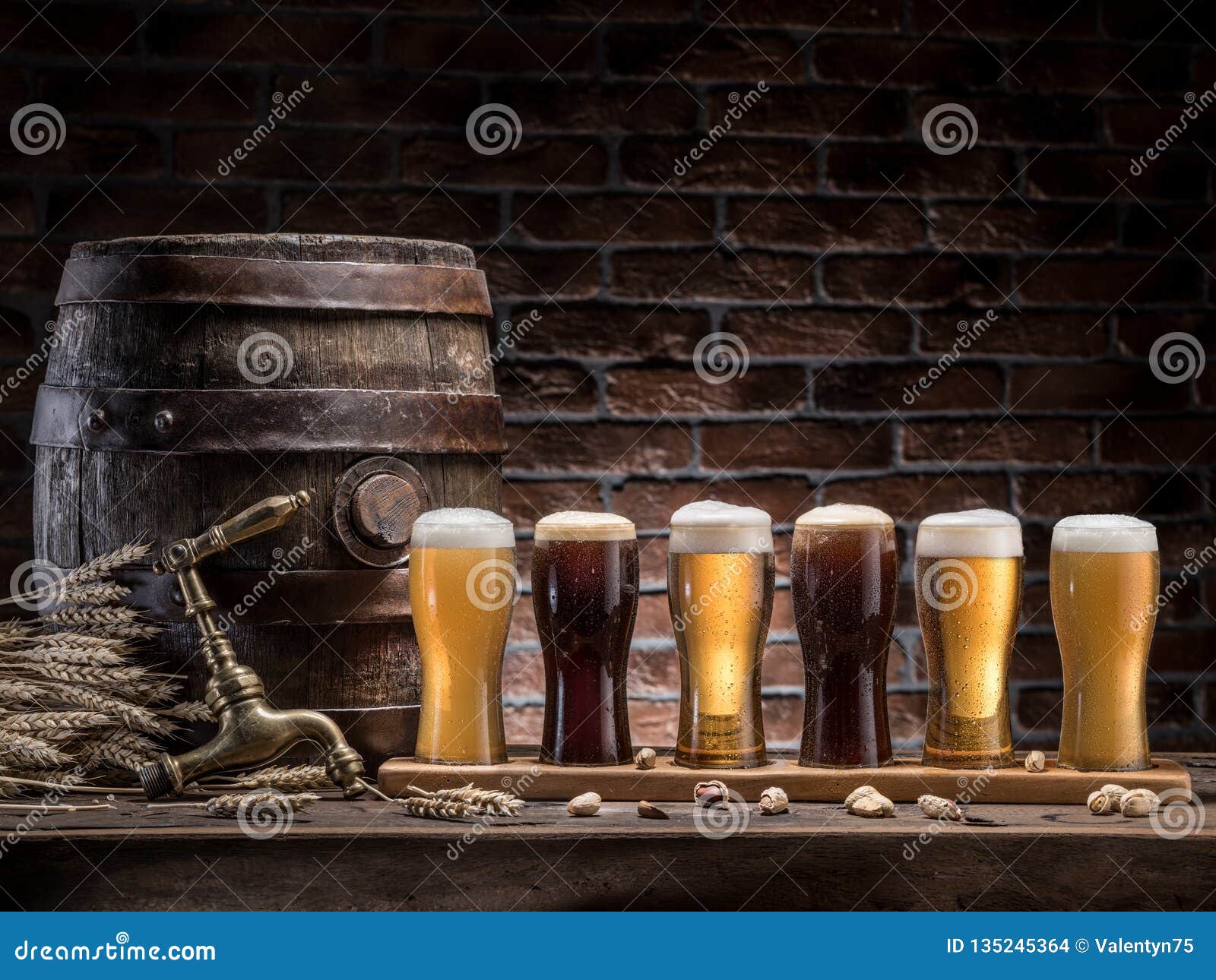 glasses of beer and ale barrel on the wooden table. craft brewery