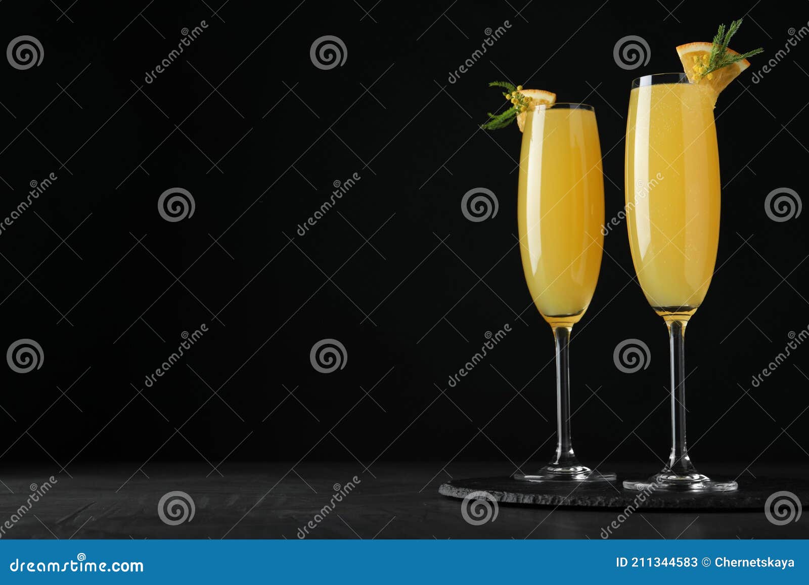 Glasses of Mimosa Cocktail with Garnish on Table. Space for Text Stock