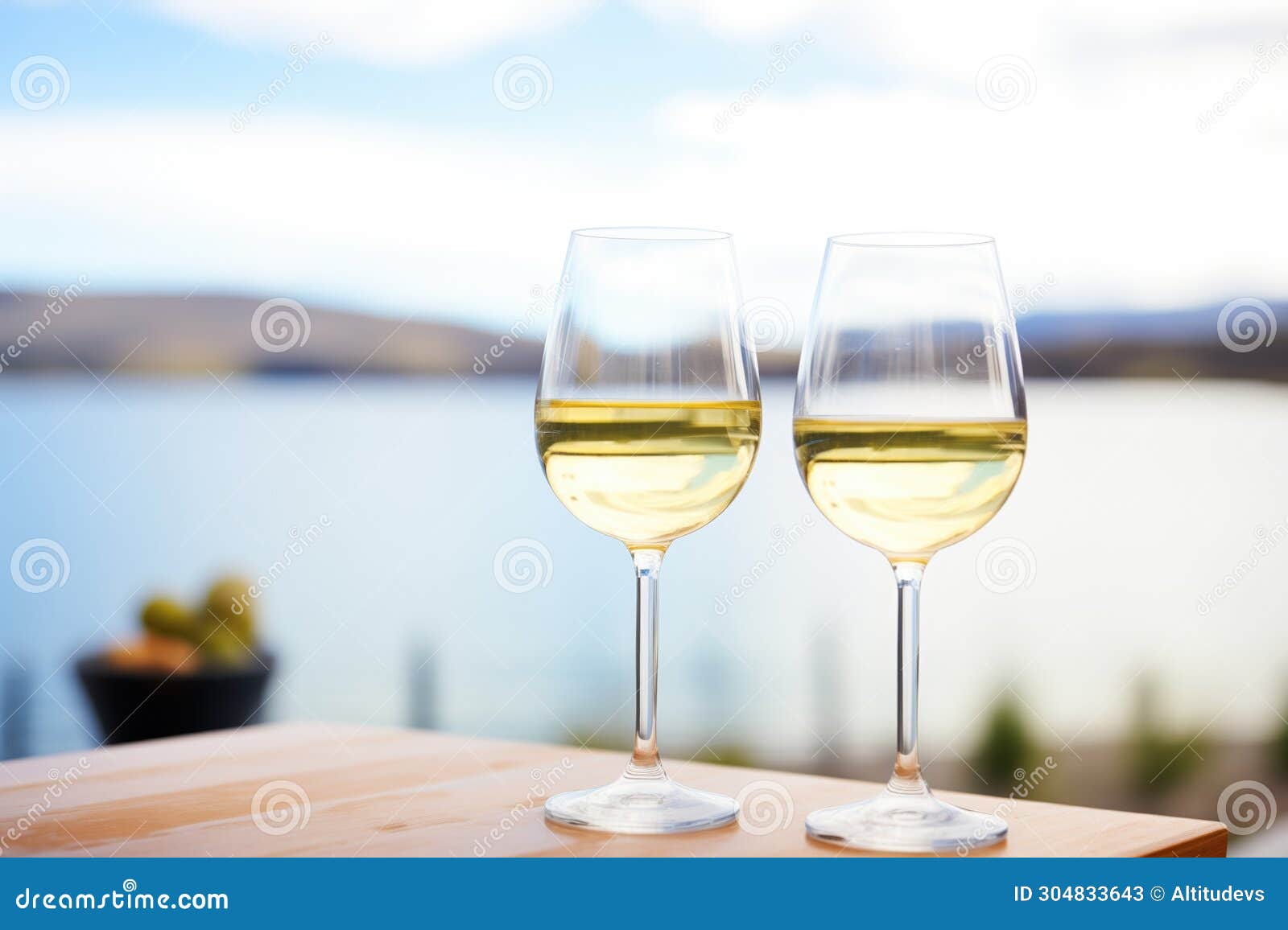 glasses of pinot grigio against a lake view