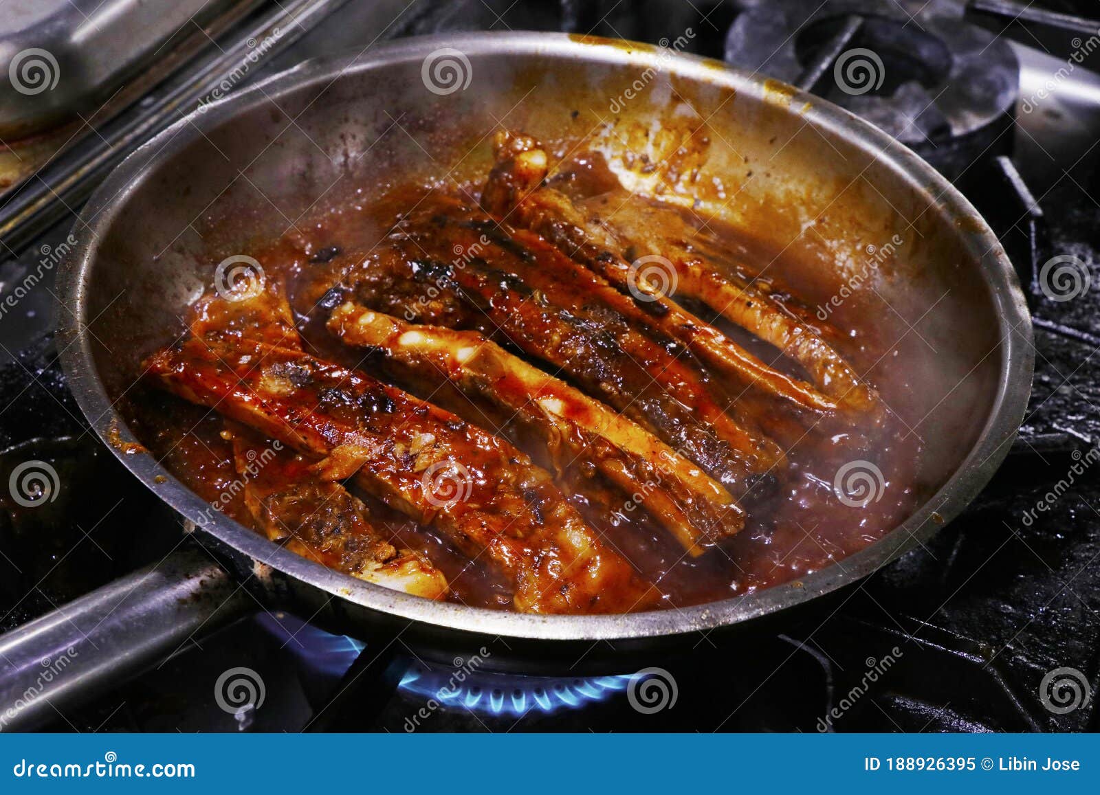 Searing A Glazed Gammon Ham Joint Of Meat. Cast Iron Frying Pan On A Hob Stove RoyaltyFree