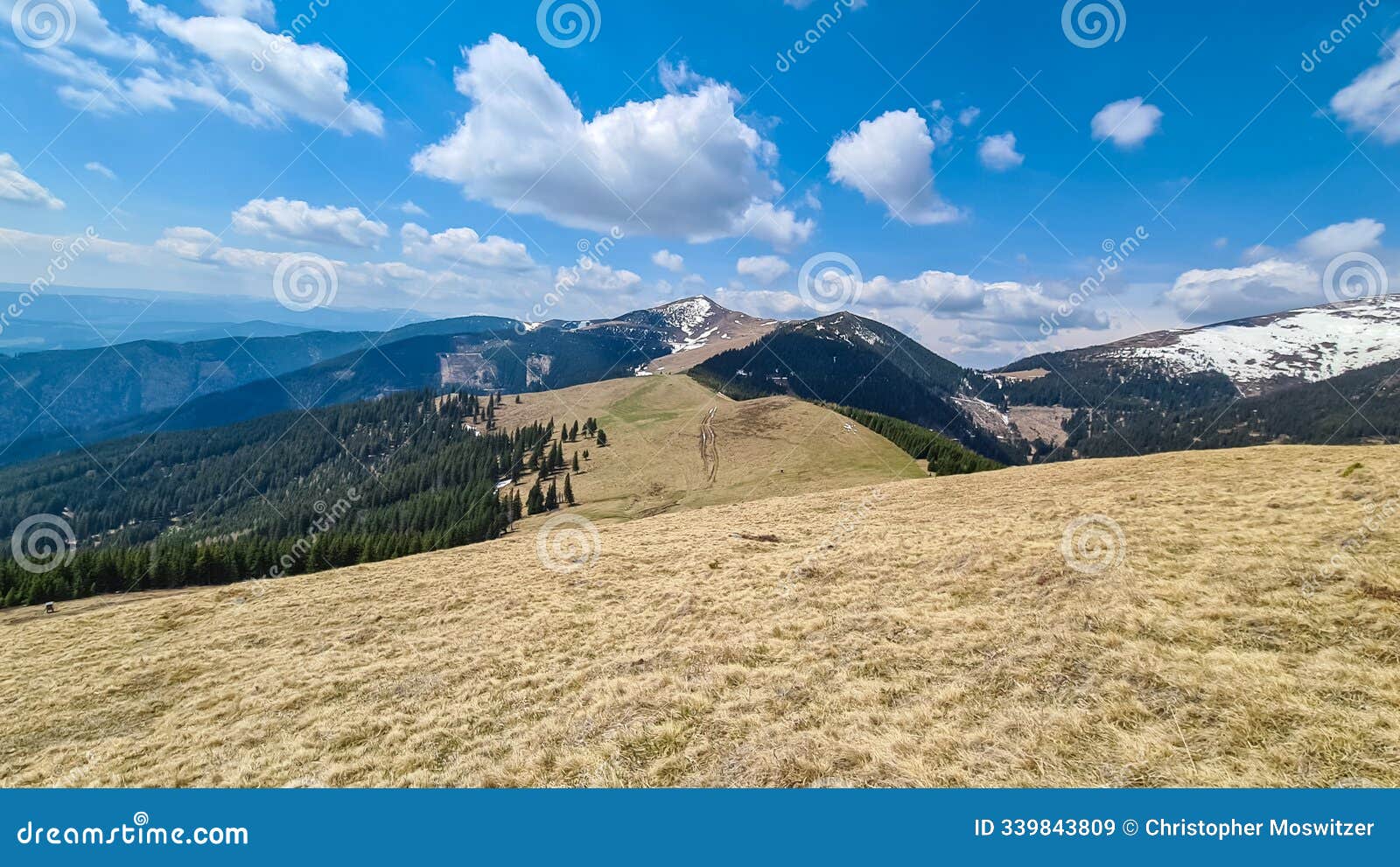 gleinalm - scenic hiking trail over dry alpine meadows and rolling hills to snow-capped mountain peak lenzmoarkogel
