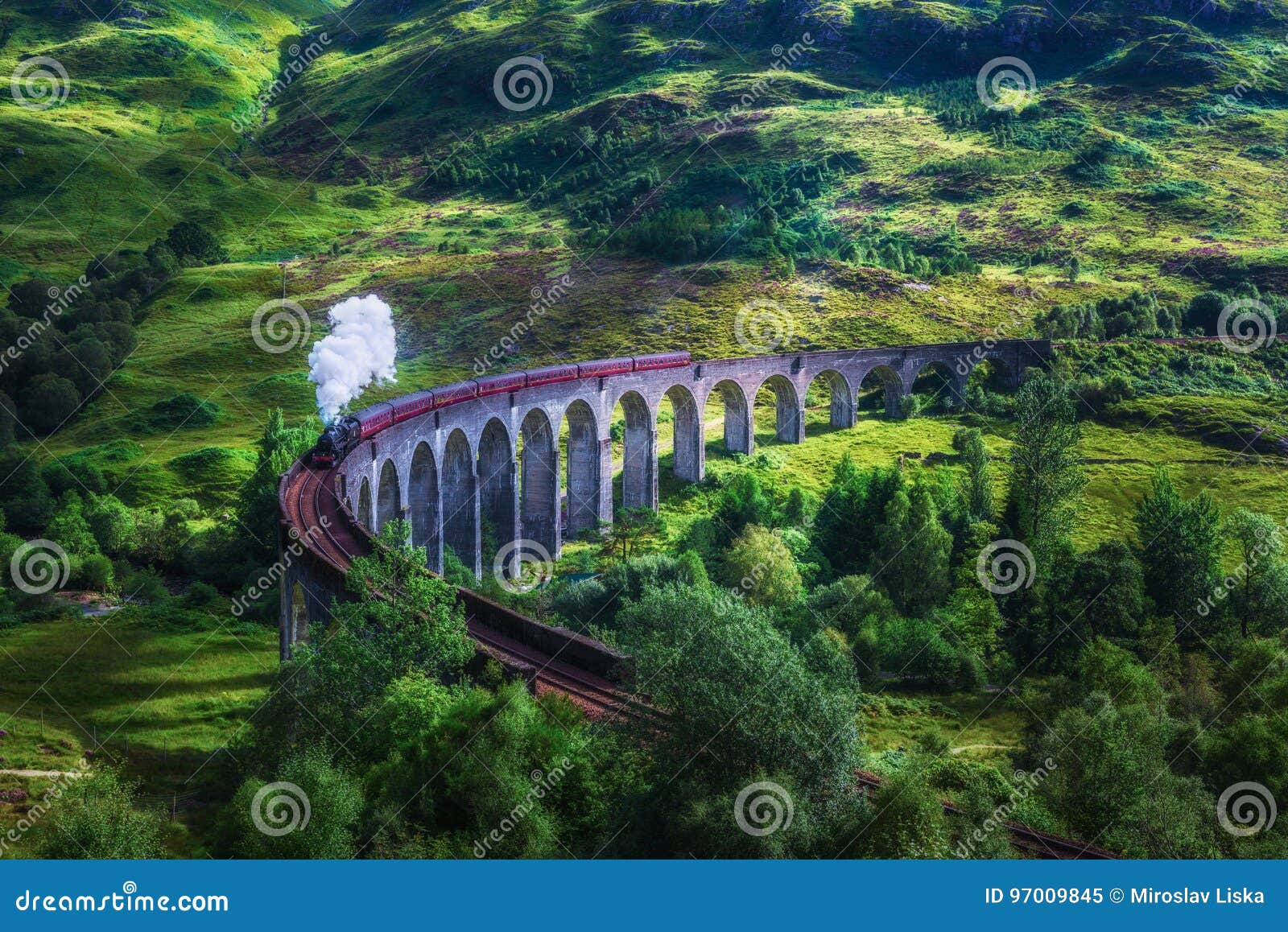 glenfinnan railway viaduct in scotland with a steam train