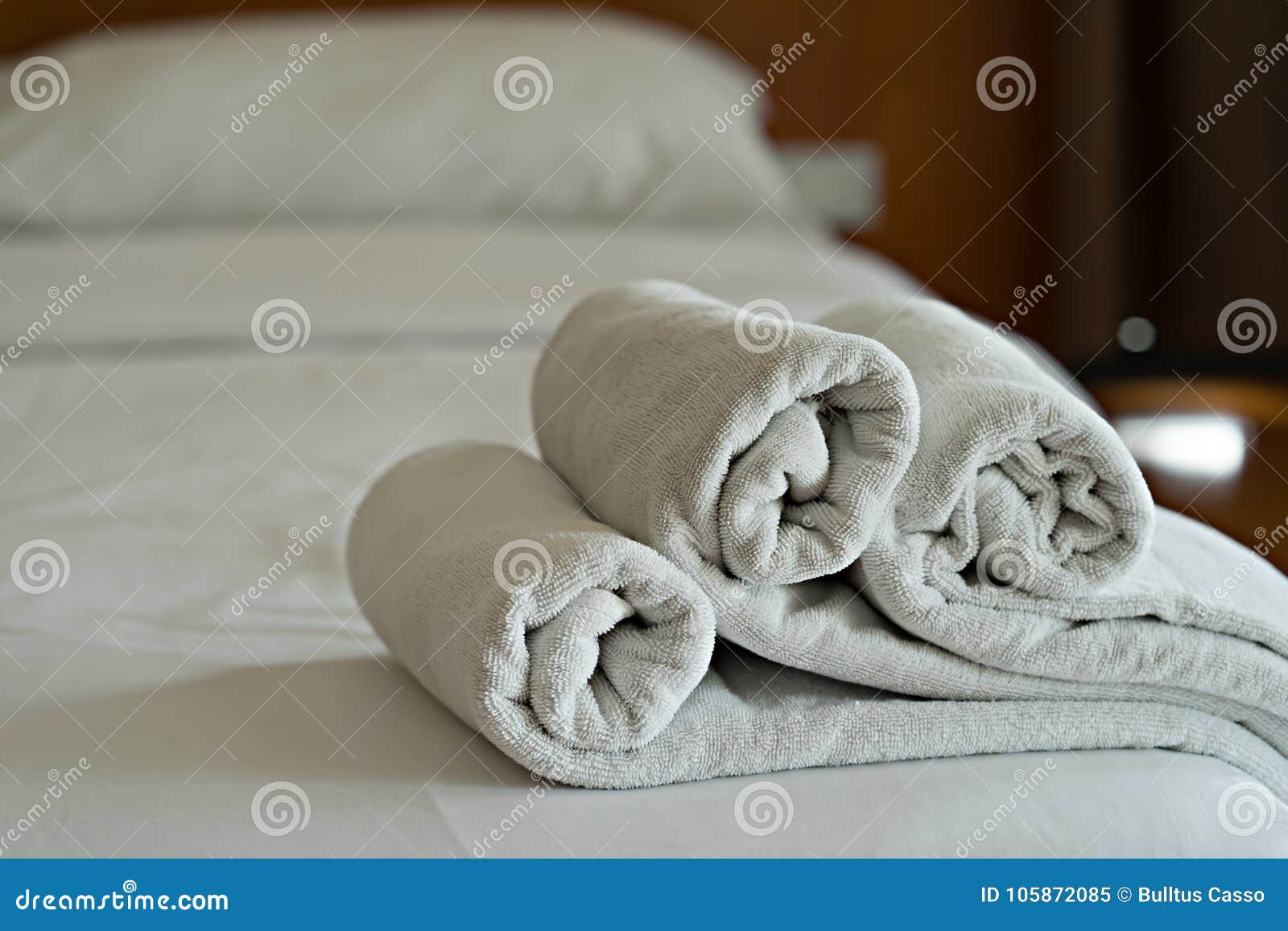 https://thumbs.dreamstime.com/z/gli-asciugamani-bianchi-rotolano-sul-letto-nella-camera-da-dell-hotel-105872085.jpg