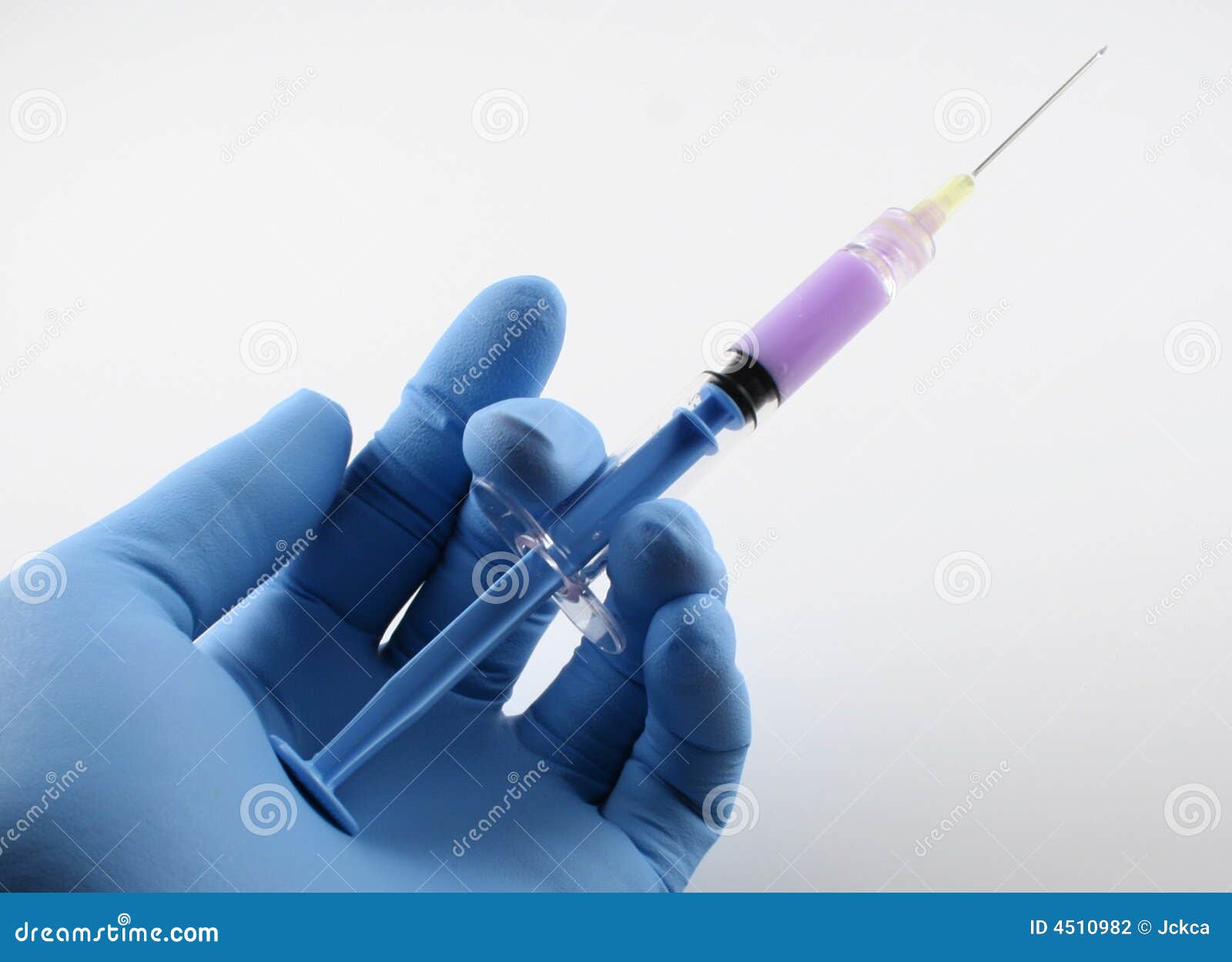 gloved hand with blue syringe