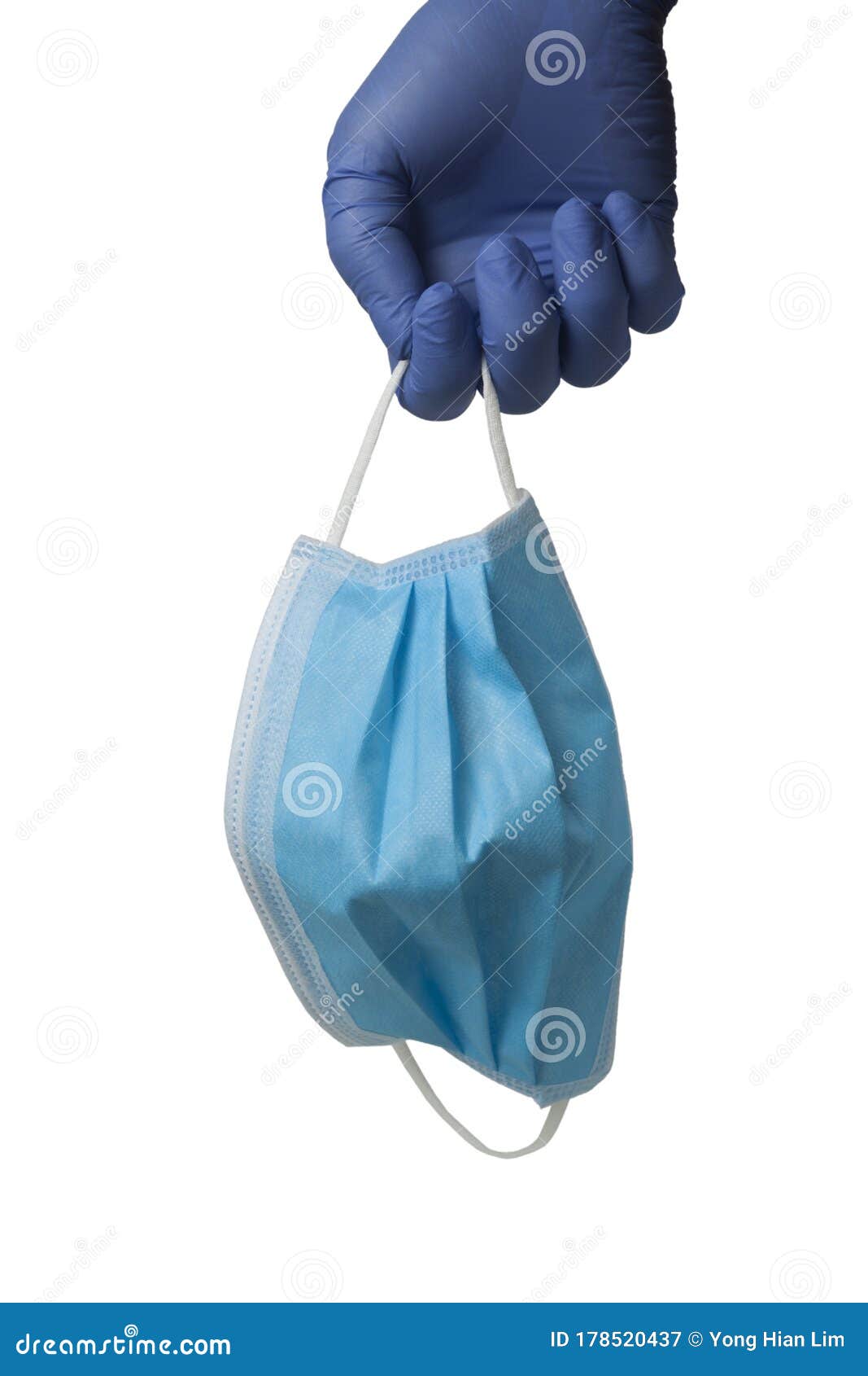 gloved hand holding a surgical mask