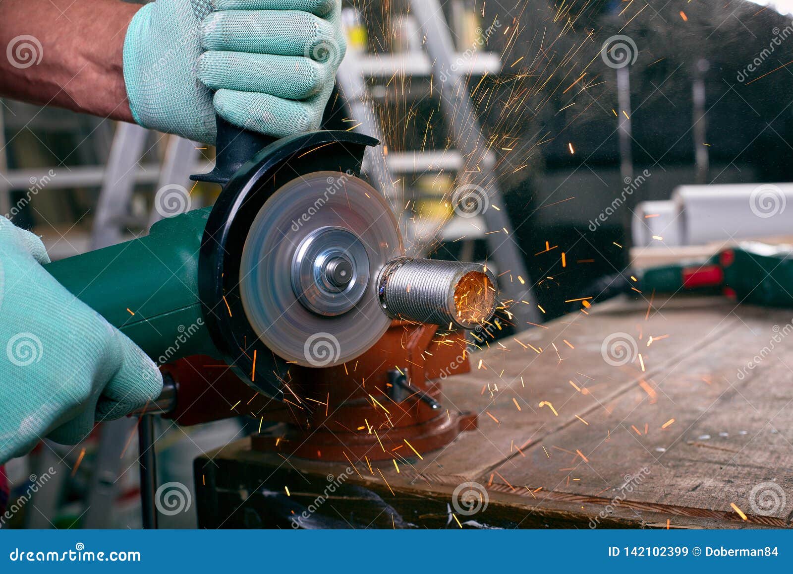Gloved Hands Hold an Angle Grinder and Cut the Pipe, Many Sparks Fly To