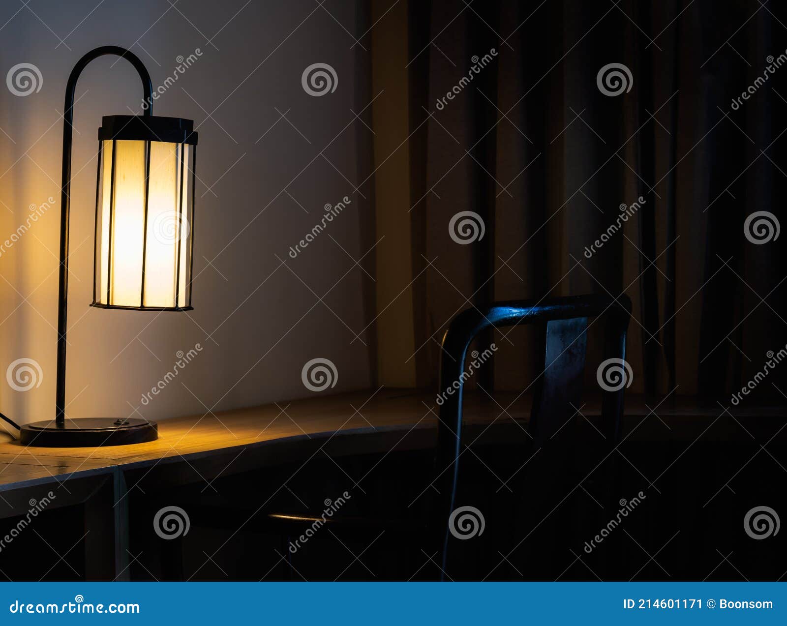 Glowing Desk Lamp on Wooden Table in the Dark Bedroom Stock Image