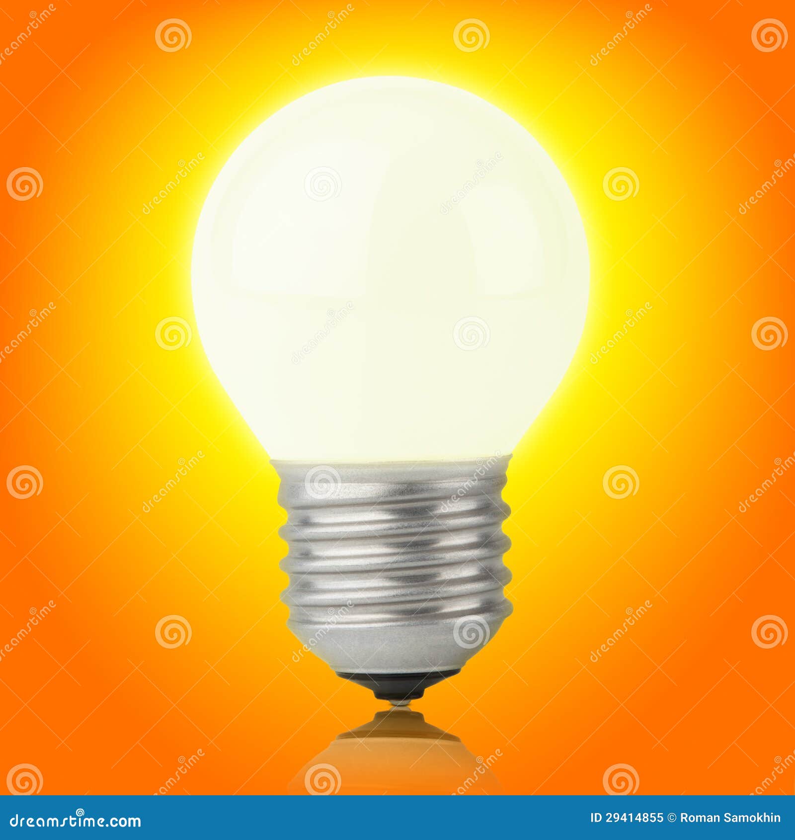 glowing incandescent light bulb on yellow-orange