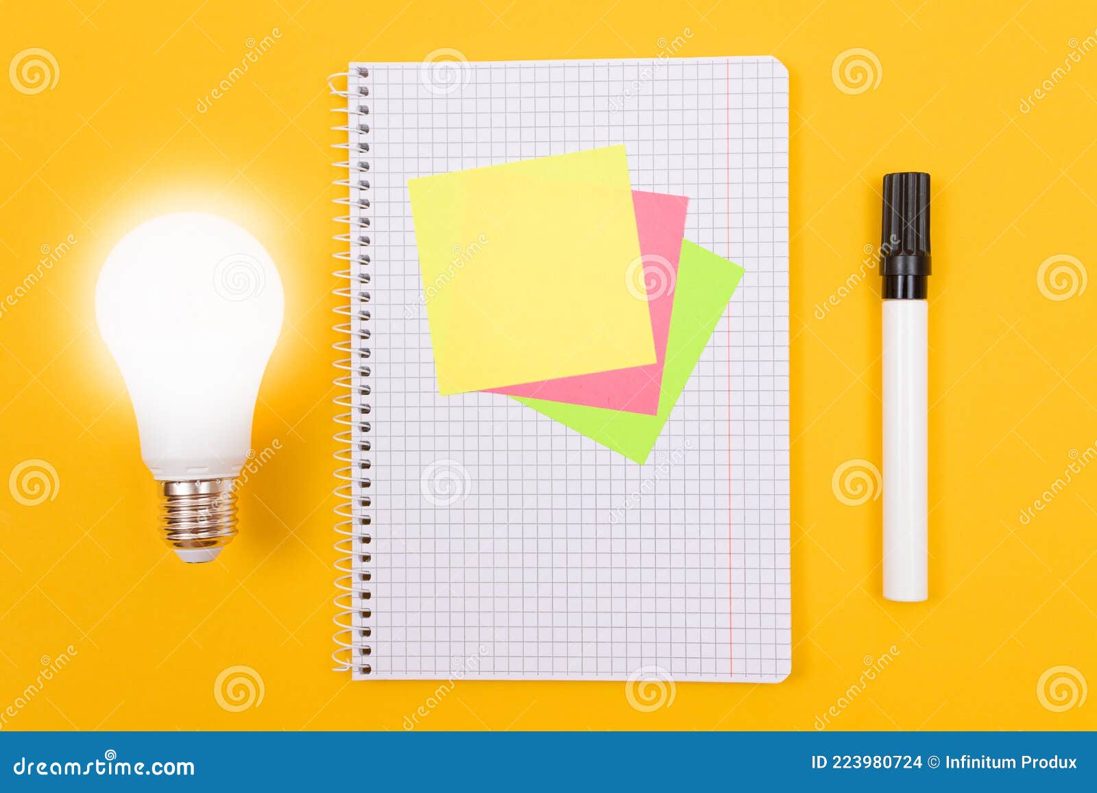 Glowing Power Saving Lamp and Notepad with Sticky Notes Stock Photo