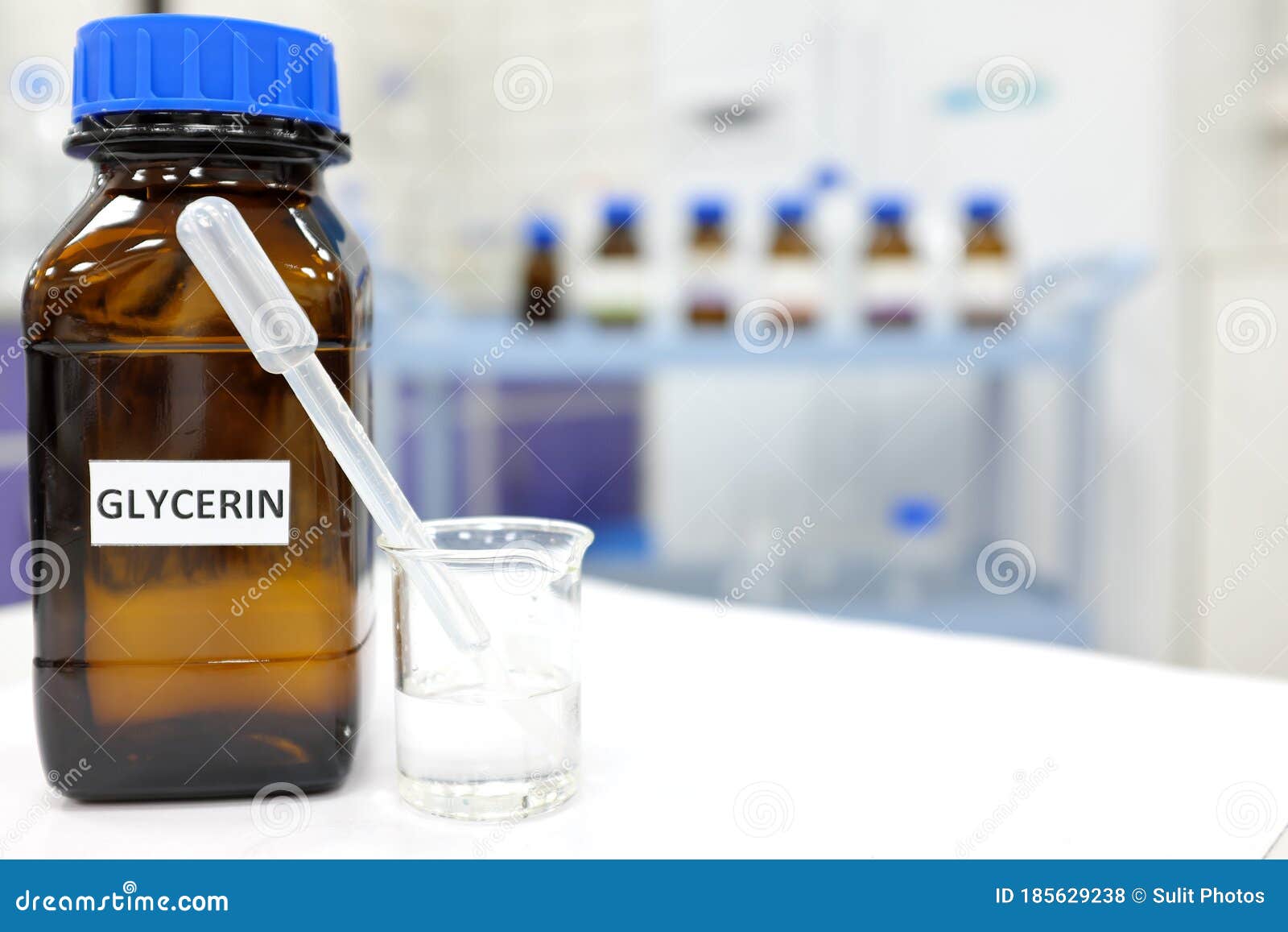 glycerin in glass beaker and brown amber bottle inside laboratory with copy space.