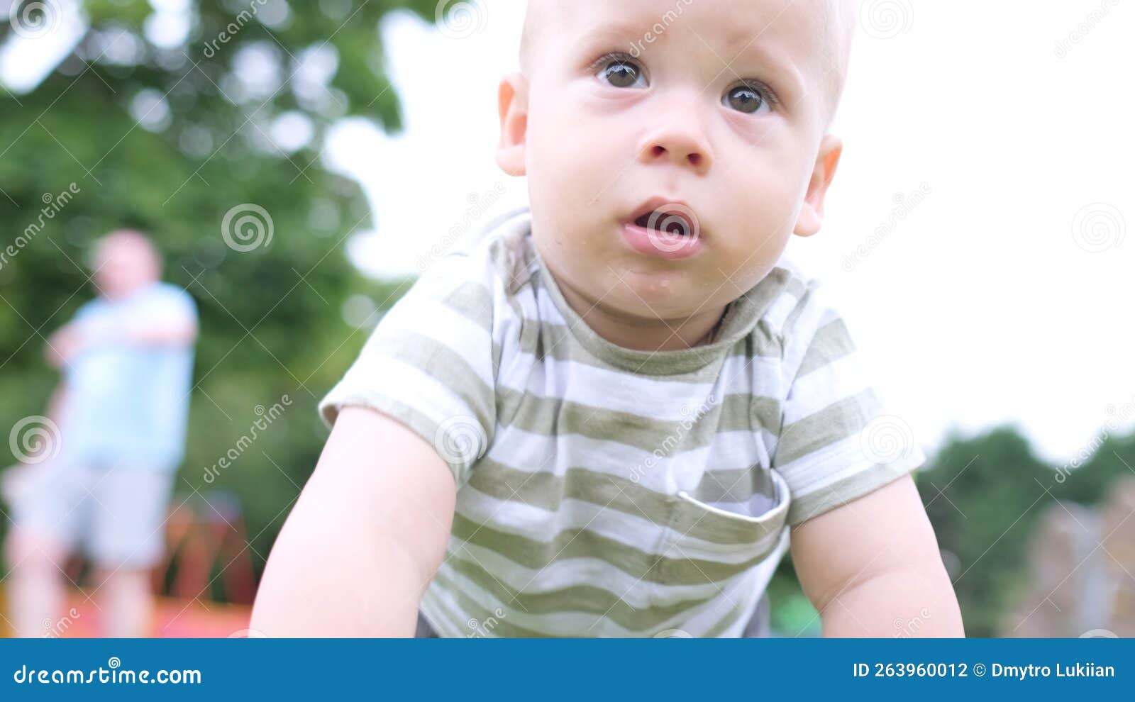 Glückliche Familie mit Picknick. Kleines Baby krabbelt auf grünem Gras. Parksommer. Geschwister Kinder, die in Grün spielen. Glückliche Familie mit Picknick. Kleines Baby krabbelt auf grünem Gras. Parksommer. Geschwister Kinder spielen im grünen Park. Familienspass und Freude am Spielplatz. Aktiver Sohn knistert barfuß im Feld.