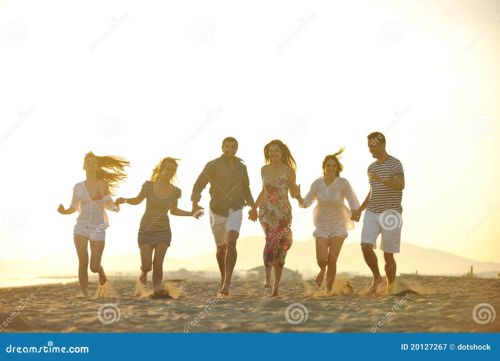 Glückliche Gruppe der jungen Leute haben Spaß auf Strand. Glückliche Gruppe der jungen Leute lassen Spaß laufen lassen und springen auf schönen Sandstrand des Strandes