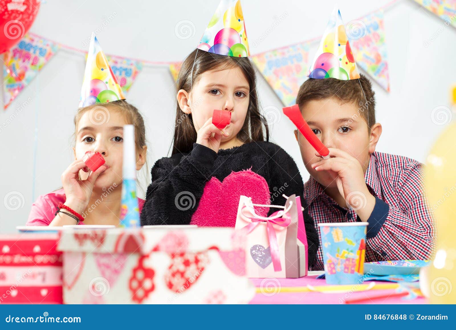 Glückliche Gruppe Kinder, die Spaß an der Geburtstagsfeier haben. Glückliche Gruppe Kinder, die Spaß an der Geburtstagsfeier auf dem weißen Hintergrund haben