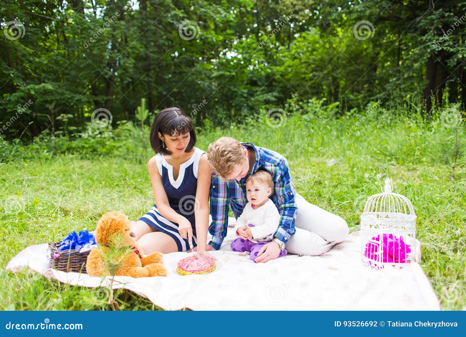 Glückliche Mischrasse-Familie, die ein Picknick hat und im Park spielt