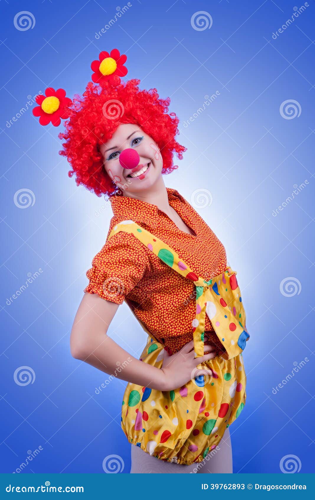 Glücklicher Frauenclown auf blauem Hintergrund. Studiobeleuchtung