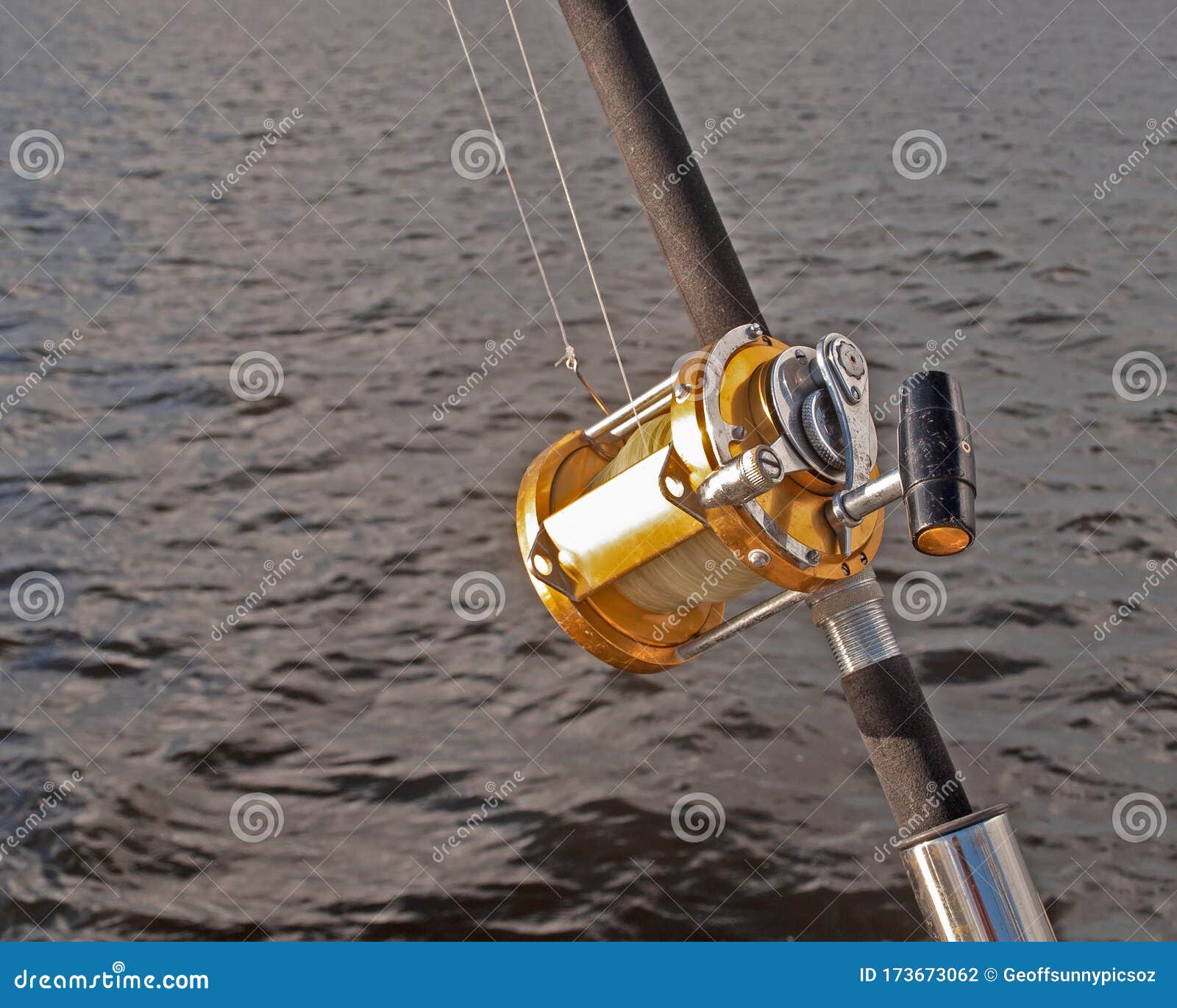 A Gold Coloured Big Game 50 Wide Fishing Reel Closeup in Used Condition  Stock Photo - Image of holder, fishing: 173673062