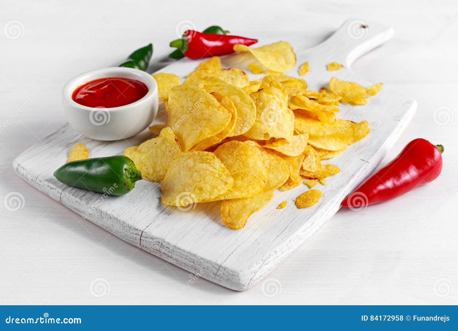 Gold and Crispy Potato Chips with Hot Sauce on White Board, Background