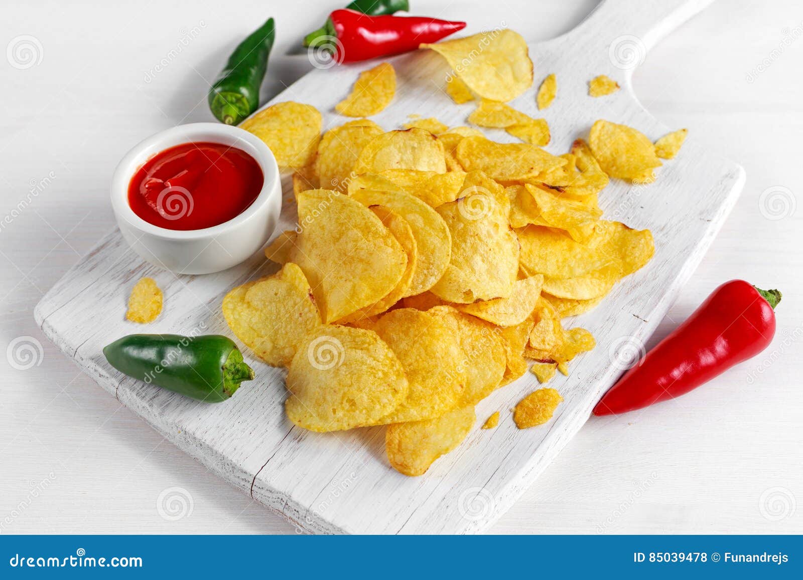 Gold and Crispy Potato Chips with Hot Sauce on White Board, Background