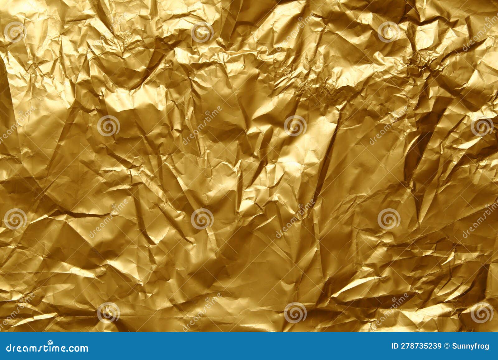 Crumpled golden aluminum foil background, abstract texture Stock