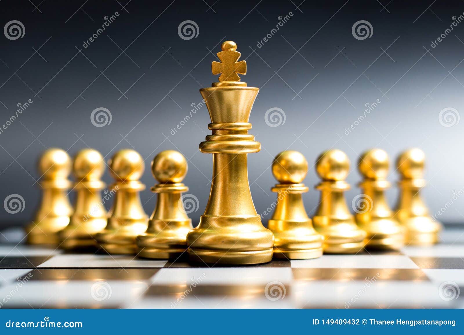 Gold king chess piece win over lying down pawn on black background