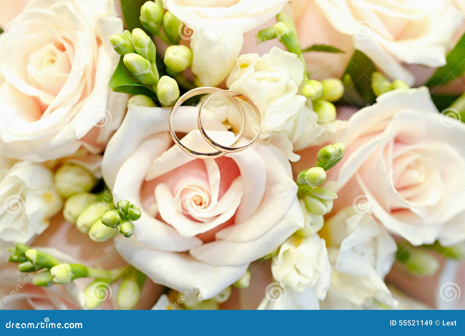Gold Wedding Rings on Bouquet of Flowers for the Bride Stock Image