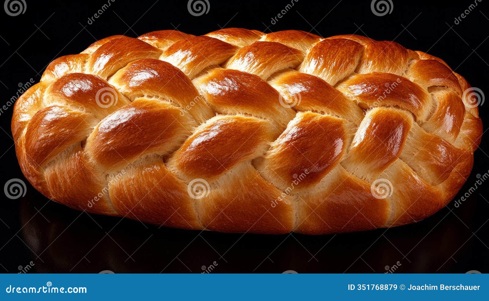 golden braided bread with shiny crust on dark background