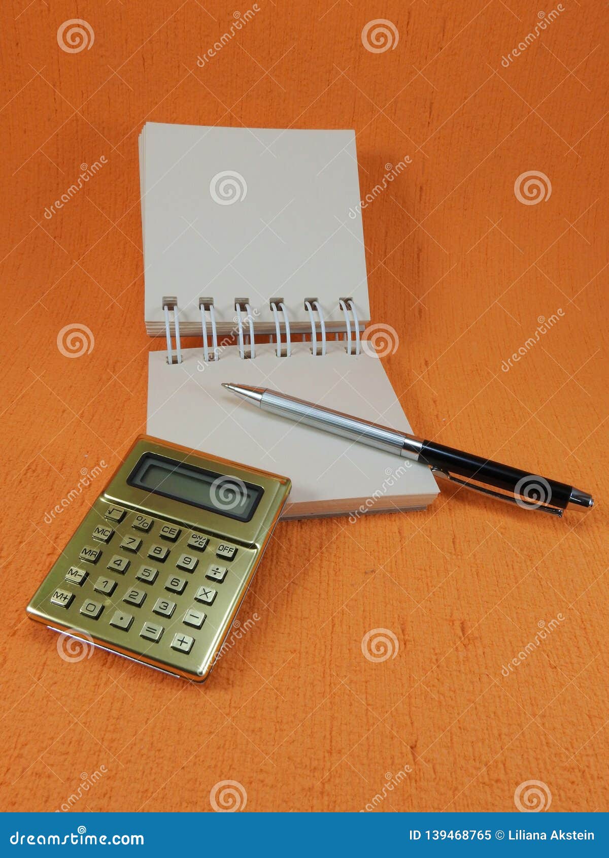 A Golden Calculator, a Small Blank Notepad and a Pen. Stock Image