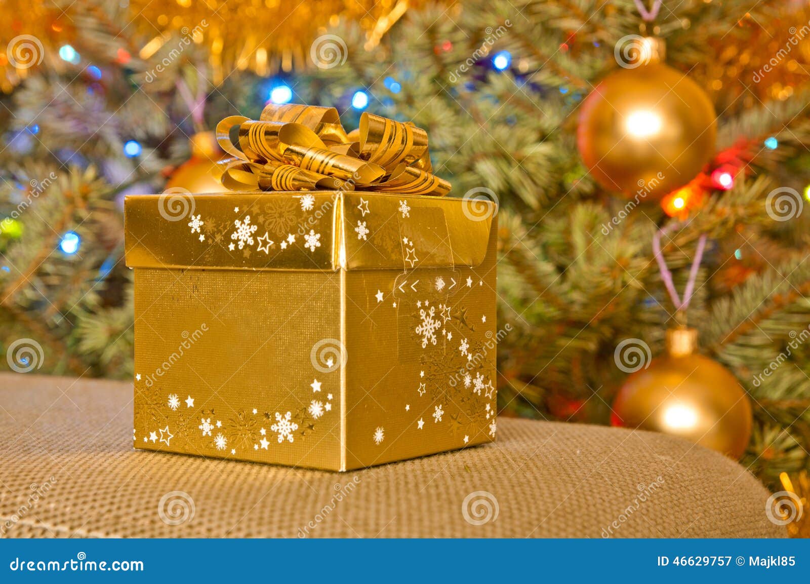 Golden Christmas Gift Next To a Christmas Tree Stock Image Image of