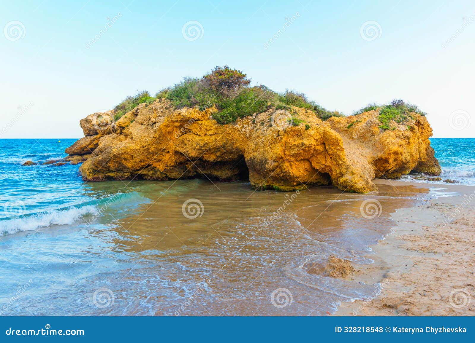 golden sand fringed by rocky coast in tarragona