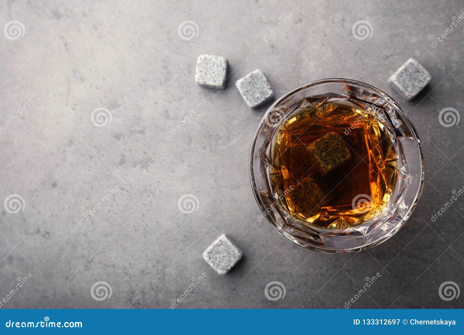 Golden Whiskey in Glass with Cooling Stones on Table, Top View. Stock