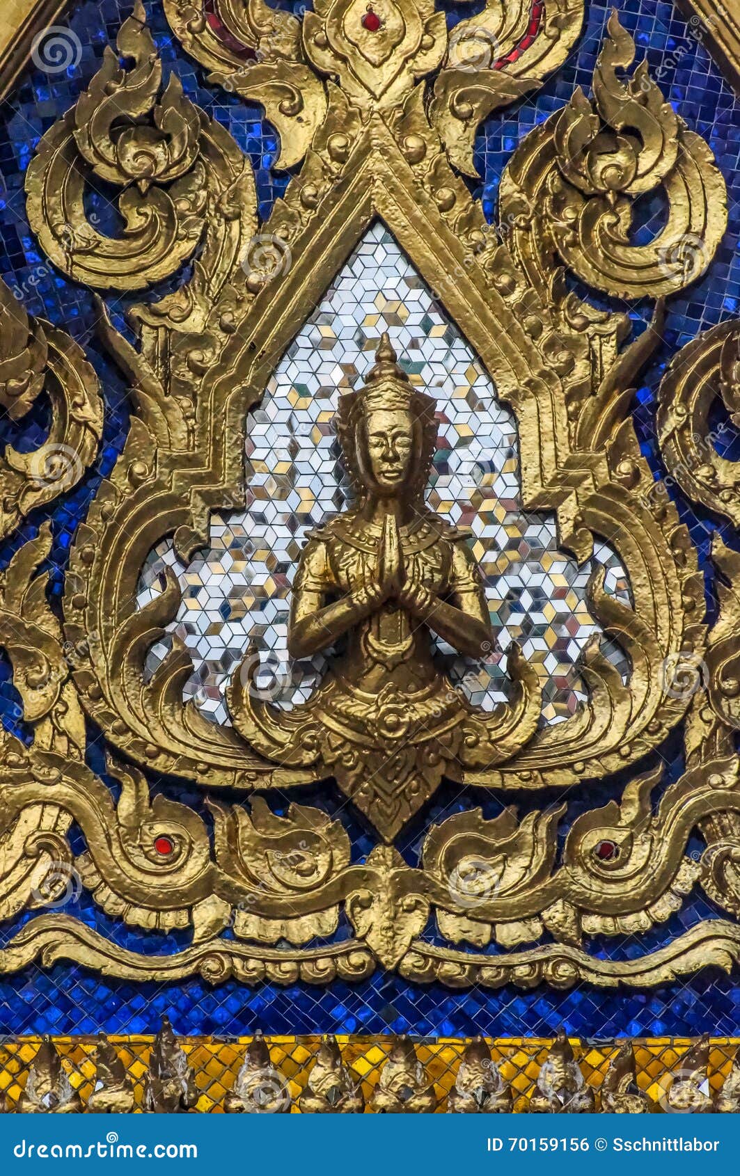 golden yaksha in front of silver and blue mirror tiles