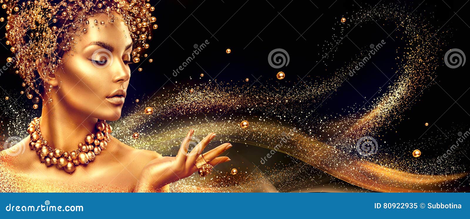Goldene Frau Schönheitsmode-modell-Mädchen mit Goldenem bilden, Haar und Schmuck auf schwarzem Hintergrund