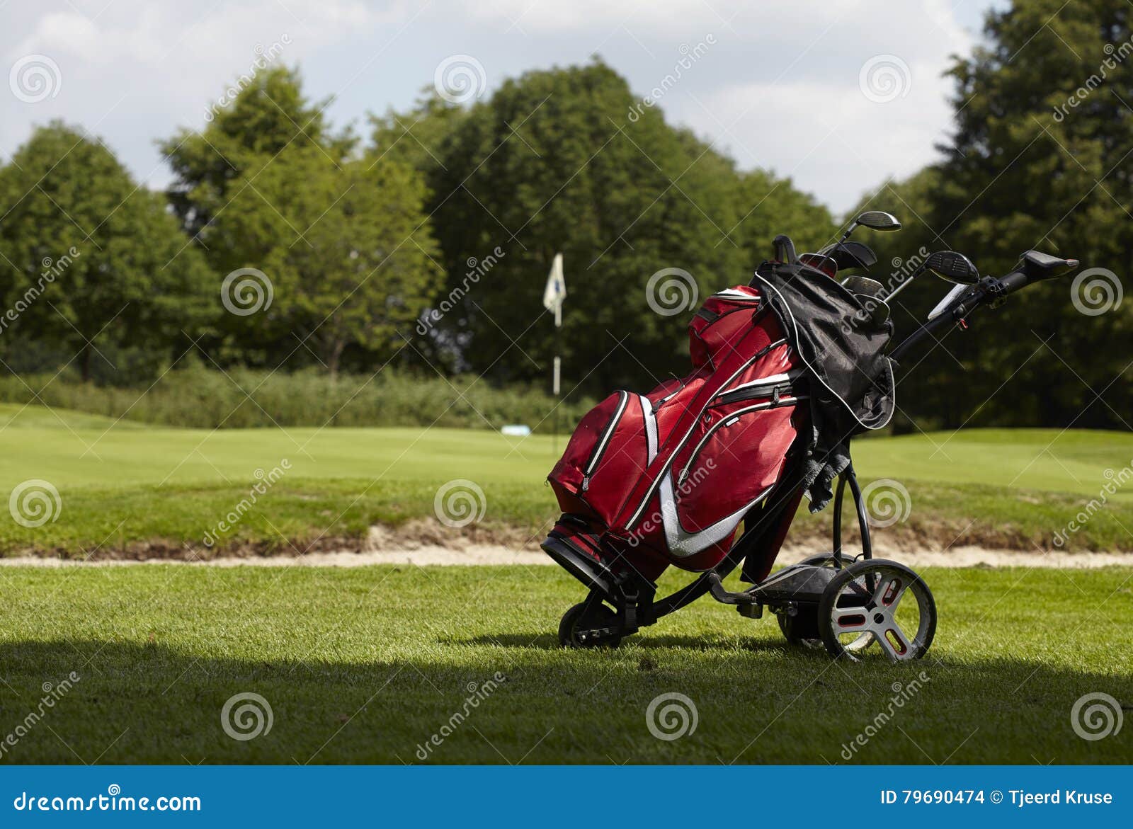 Golf Bag with Several Clubs on a Trolley on the Fairway Stock Photo