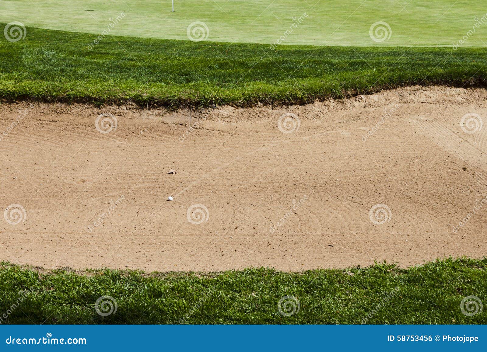 Golf Ball on a Bunker Sand Trap Hazard in a Golf Course. Stock Photo