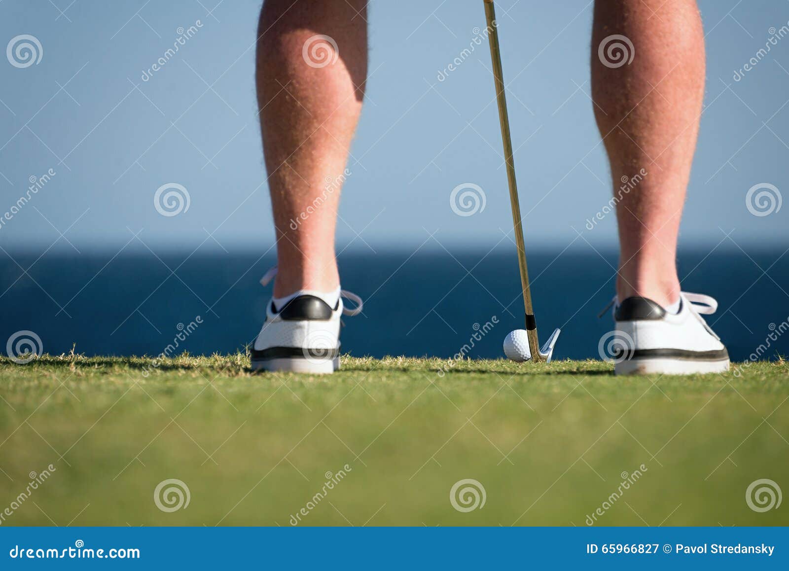 Golf Ball And Stick With Golfer Legs In The Foreground Stock Image