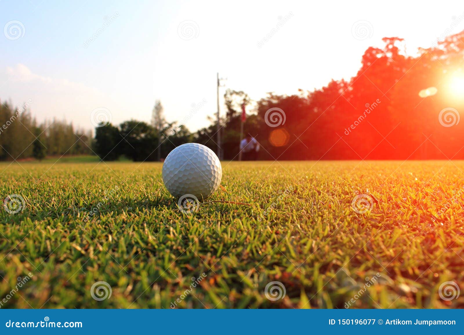 Golfball im grünen Rasen verwischen den Golfspieler, der die Weise betrachtet, die der Golfball Löcher gebildet wird