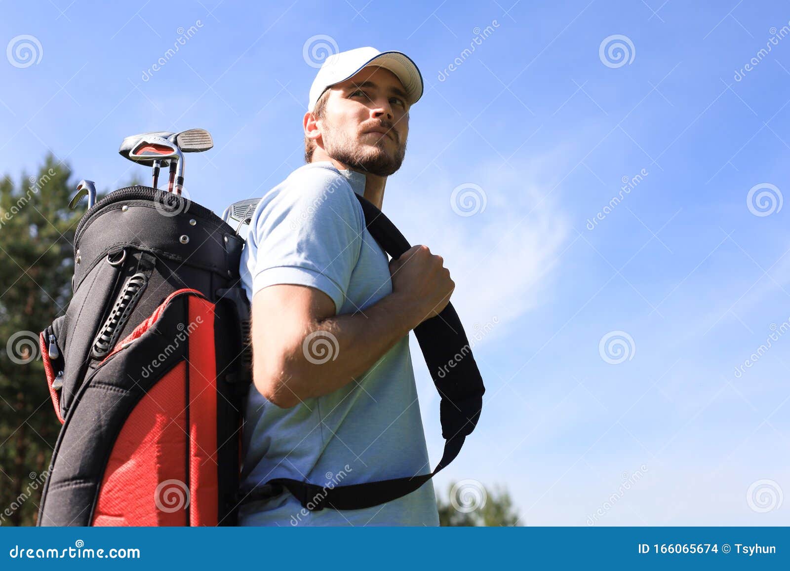 Golf Player Walking and Carrying Bag on Course during Summer Game