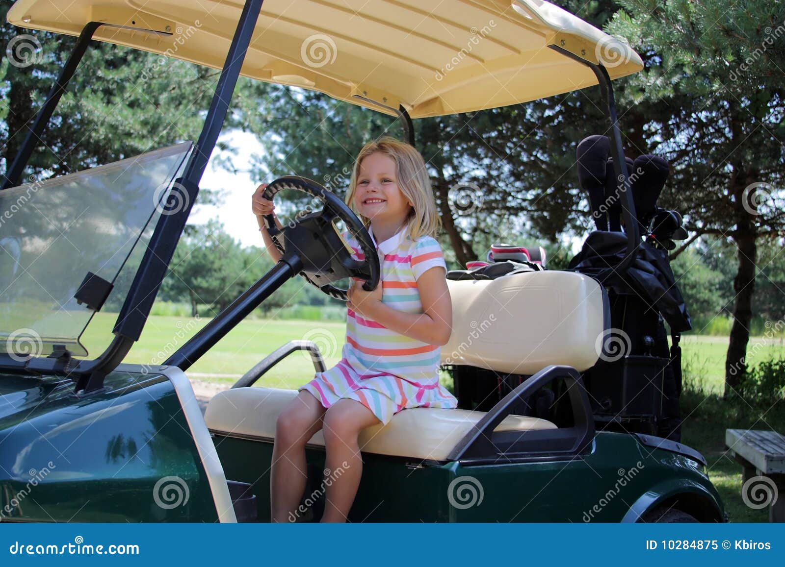 Golf-Transportgestell. Ein yound Mädchen, das einen Golfwagen antreibt.