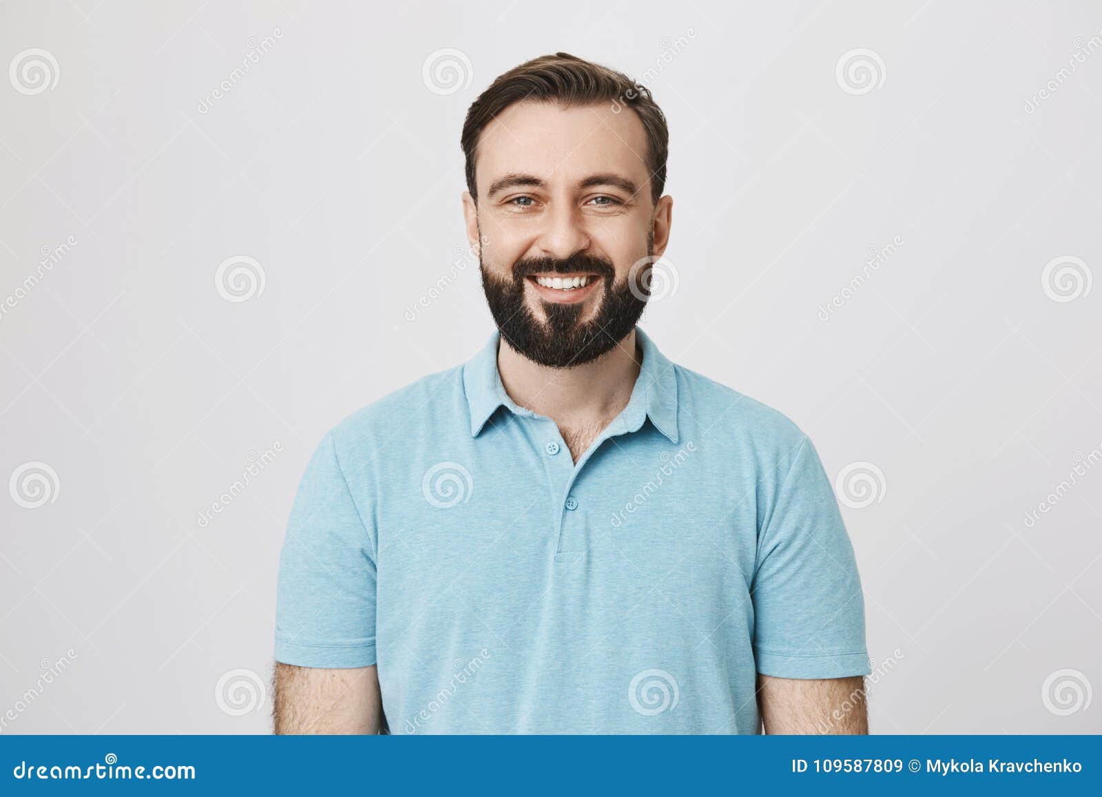 good-looking european male adult with beard and moustache smiling broadly over gray background. boyfriend stand behind