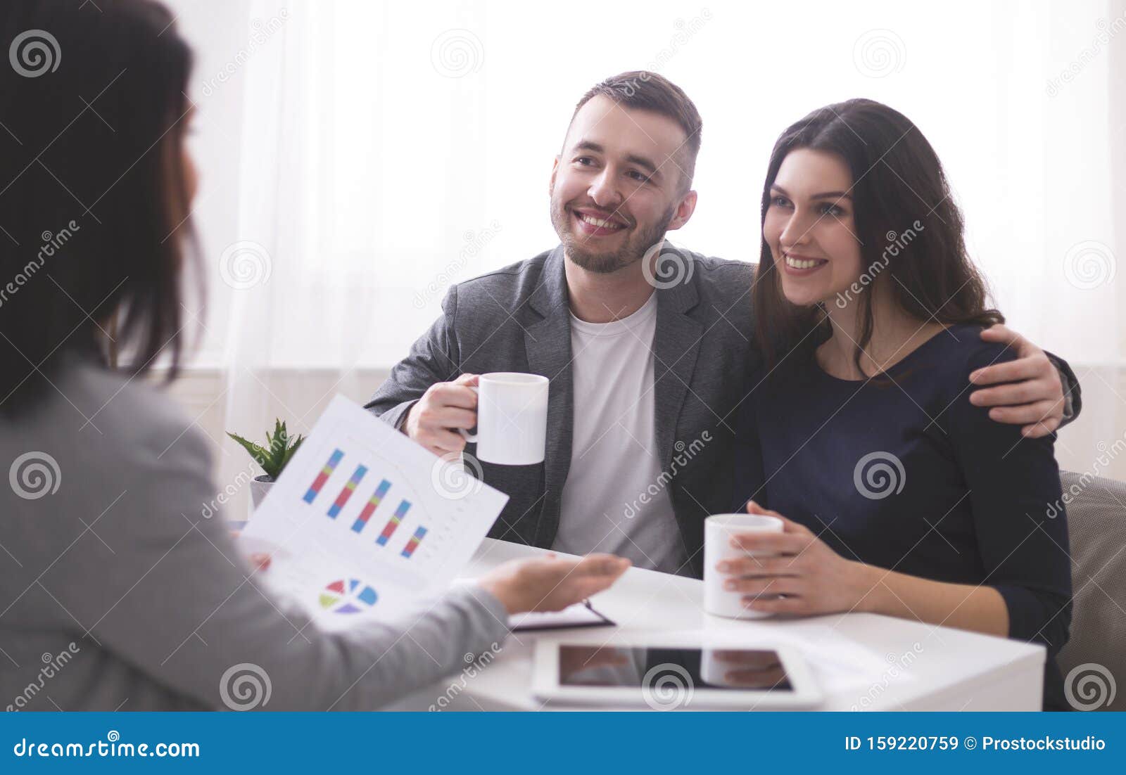 young millennial couple enjoying coffee, listening to financial advisor