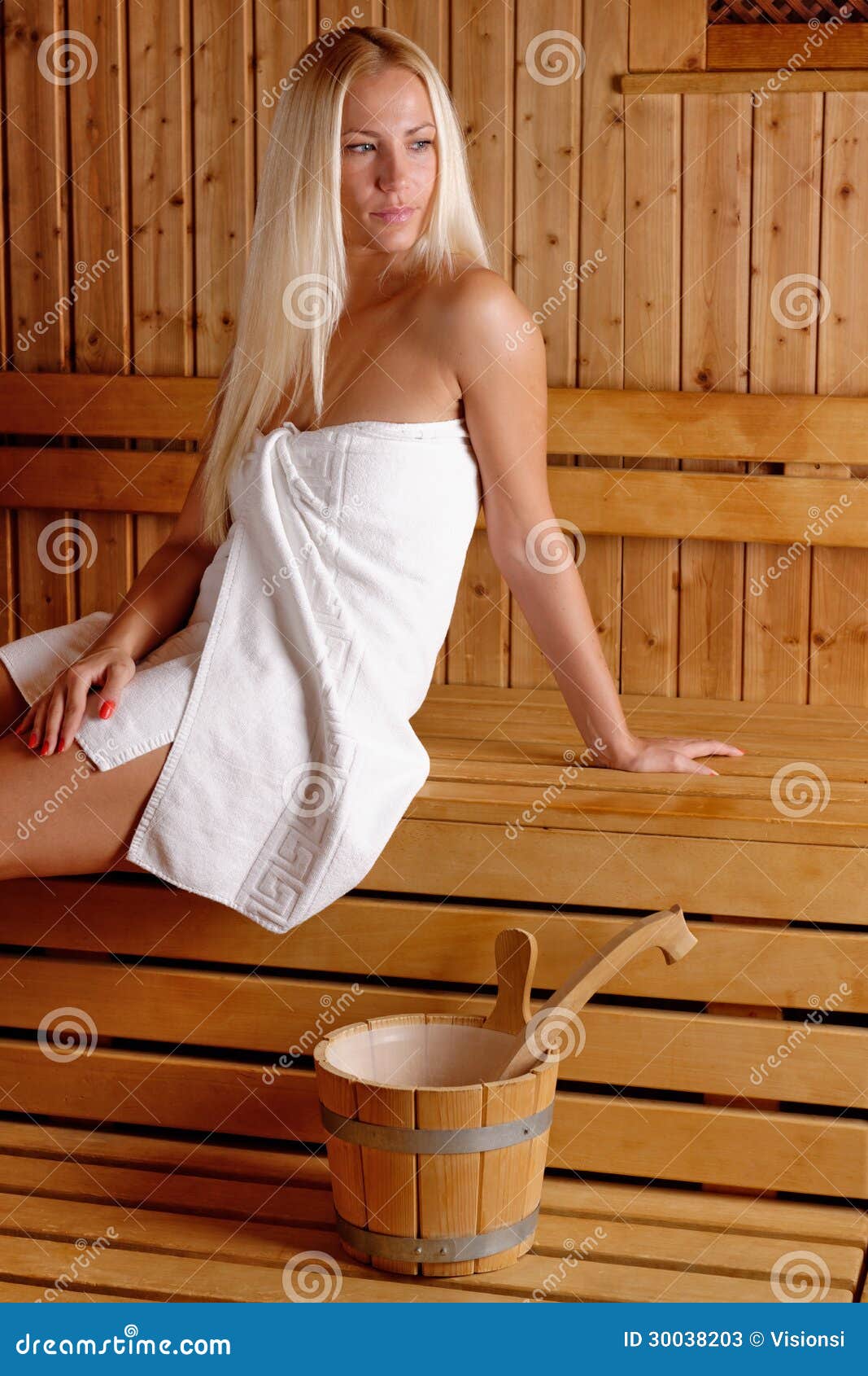 Attractive And Smiling Woman In Towels Looking At Camera In Sauna