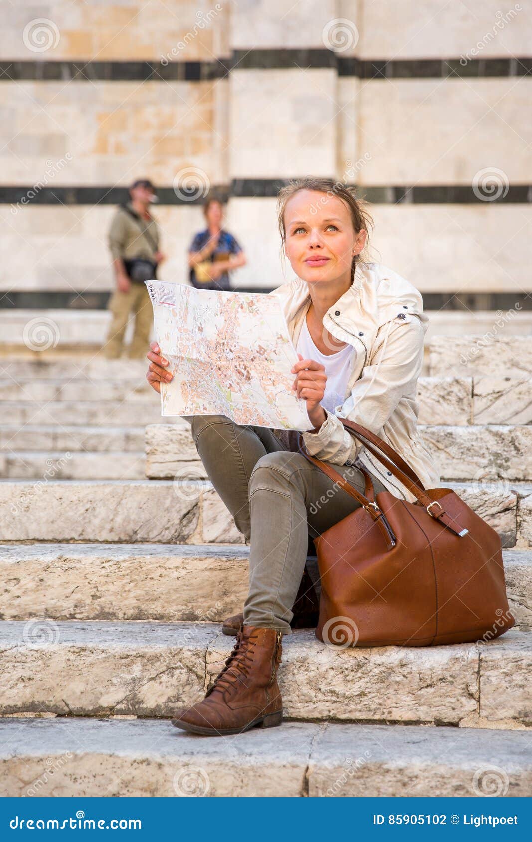 gorgeous female tourist with a map discovering a foreign city