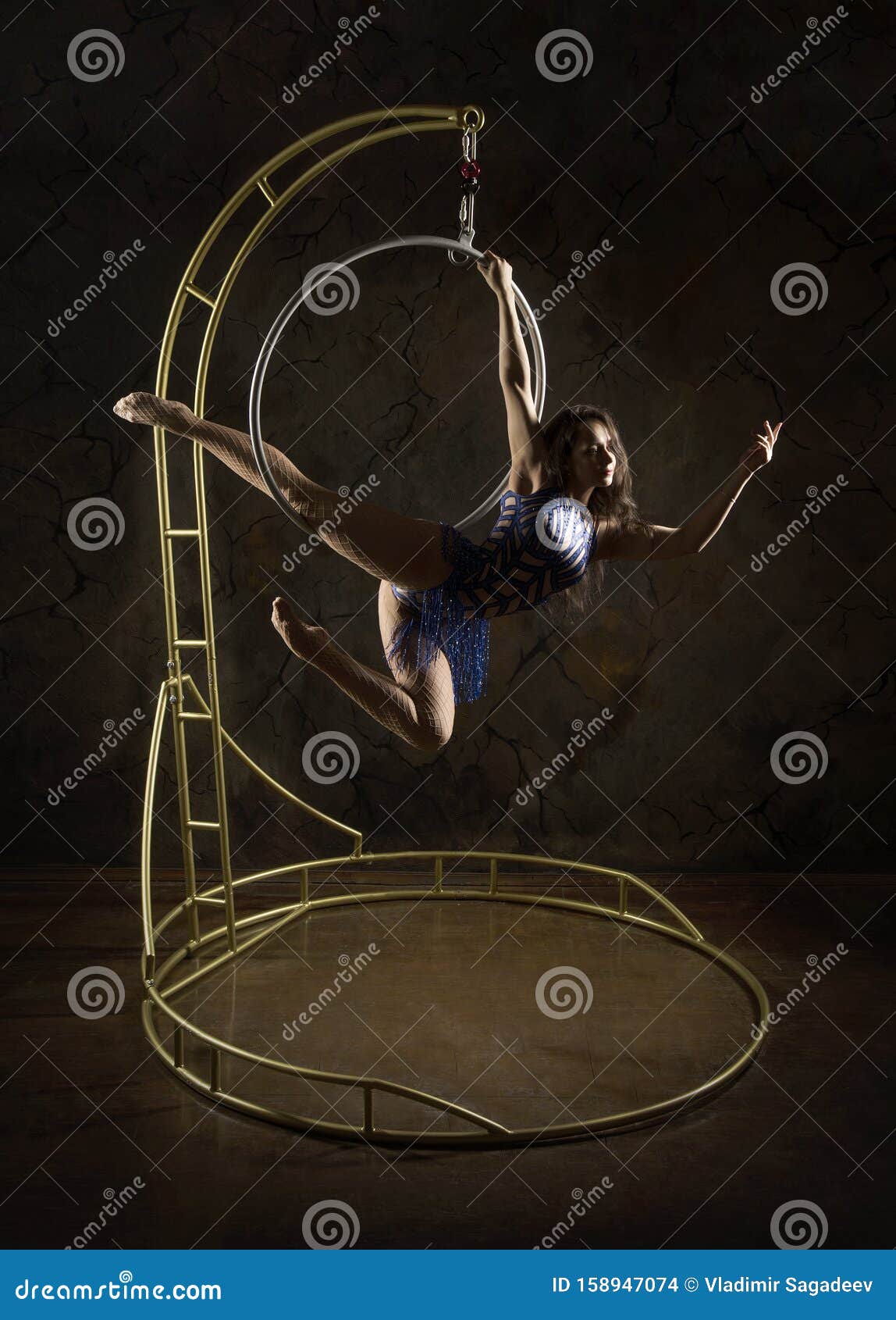 gorgeous girl aerial acrobatics stage blue dress takes acrobatic elements portable air ring lighting studio shooting 158947074