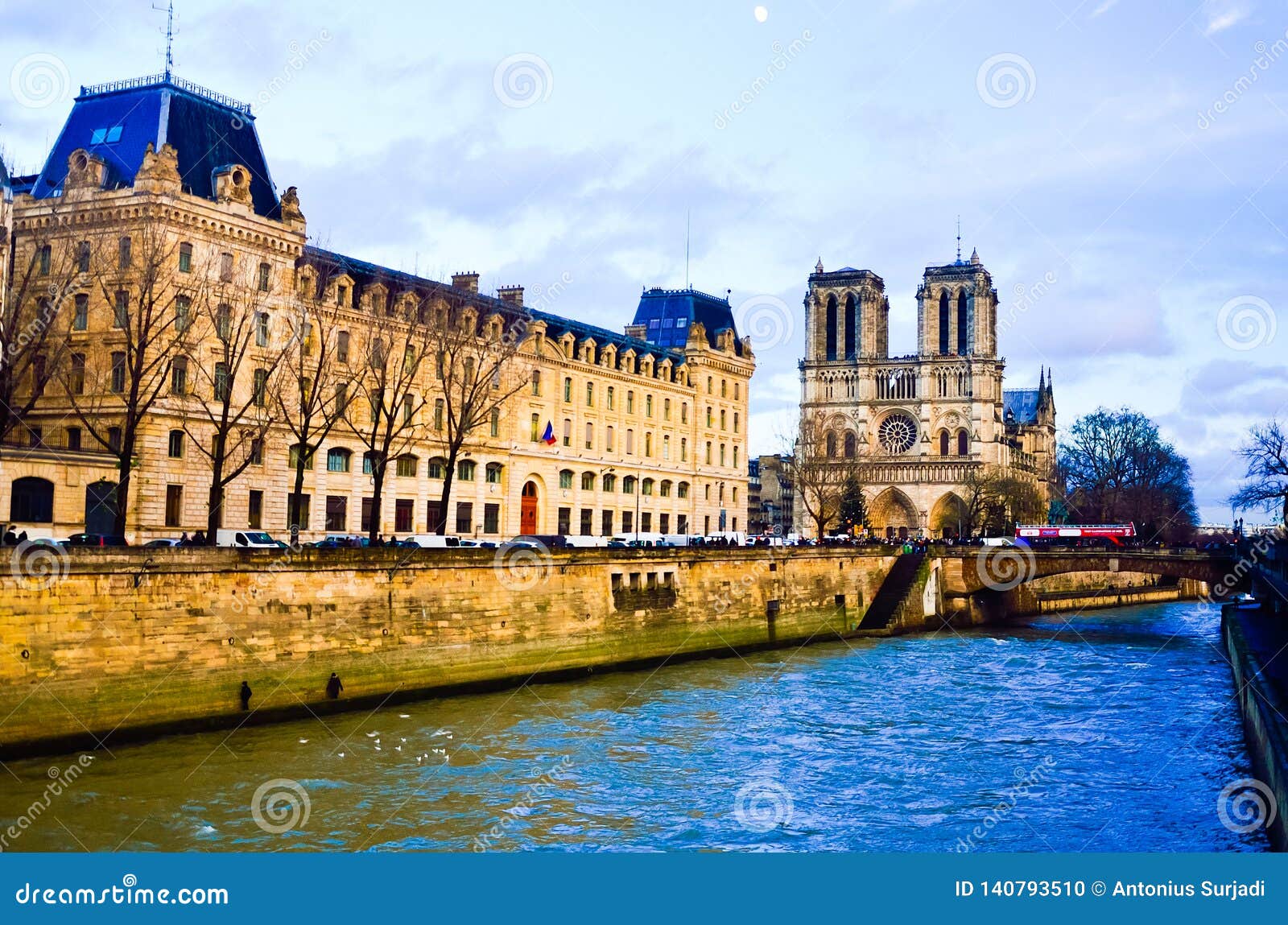 Calm peaceful ancient traditional historical building in the sunset time. Gorgeous and peaceful stone building with Notre Dame cathedral church on the side of city river in Paris Europe