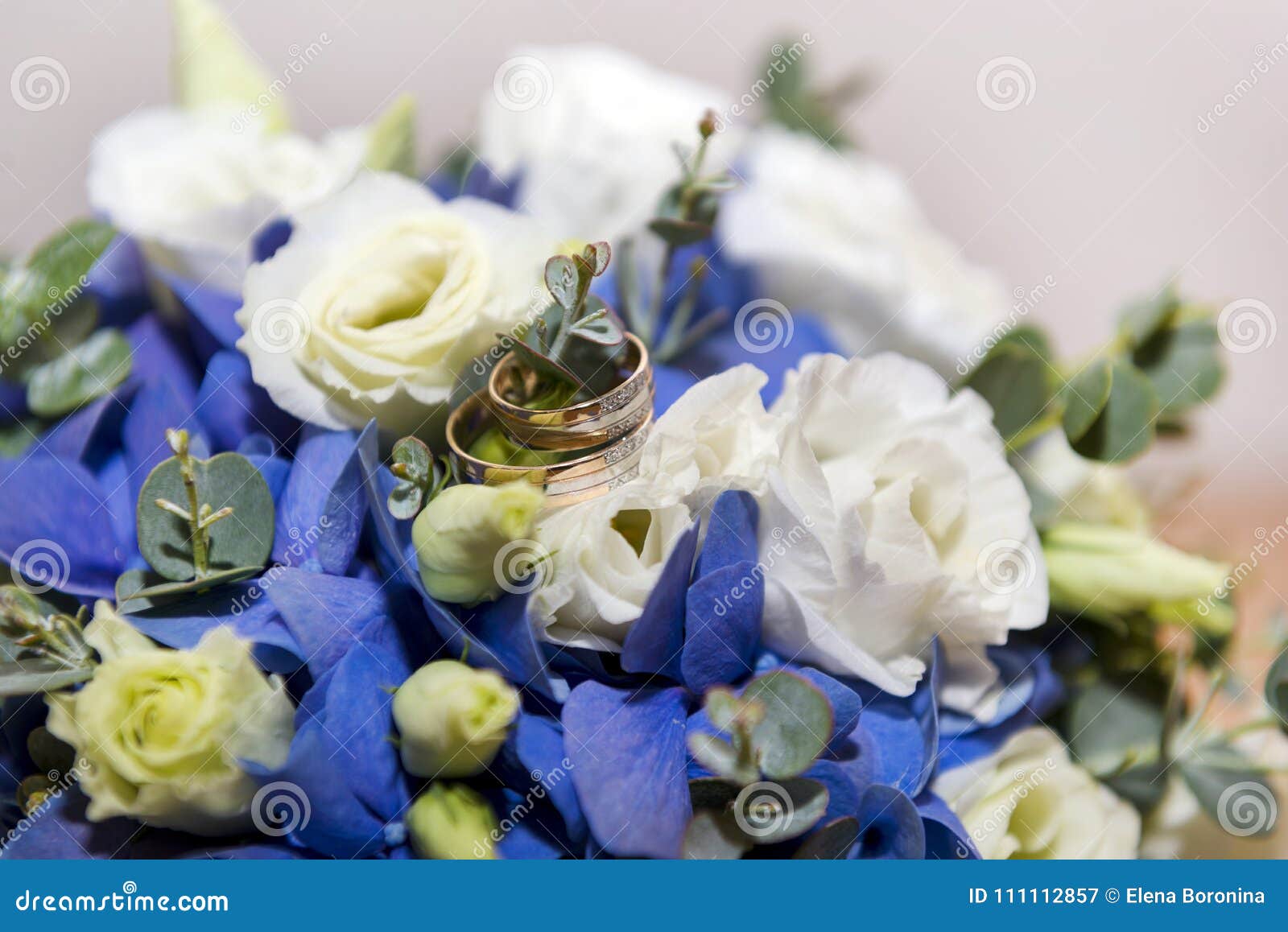 Wonderbaar Gouden Trouwringen Op Een Boeket Van Witte En Blauwe Bloemen Stock MM-89