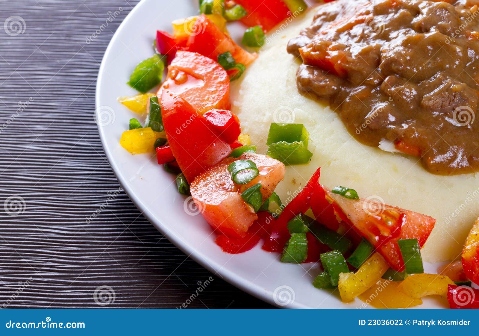 Goulash de carne com prato das batatas. Goulash de carne com batatas e salada dos vegetais na placa