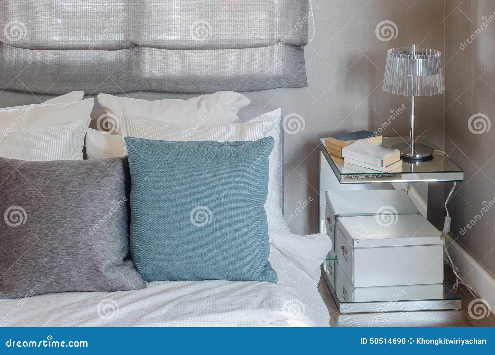 Grå färg och gräsplankudde på vit säng i modernt sovrum arkivfoto ...