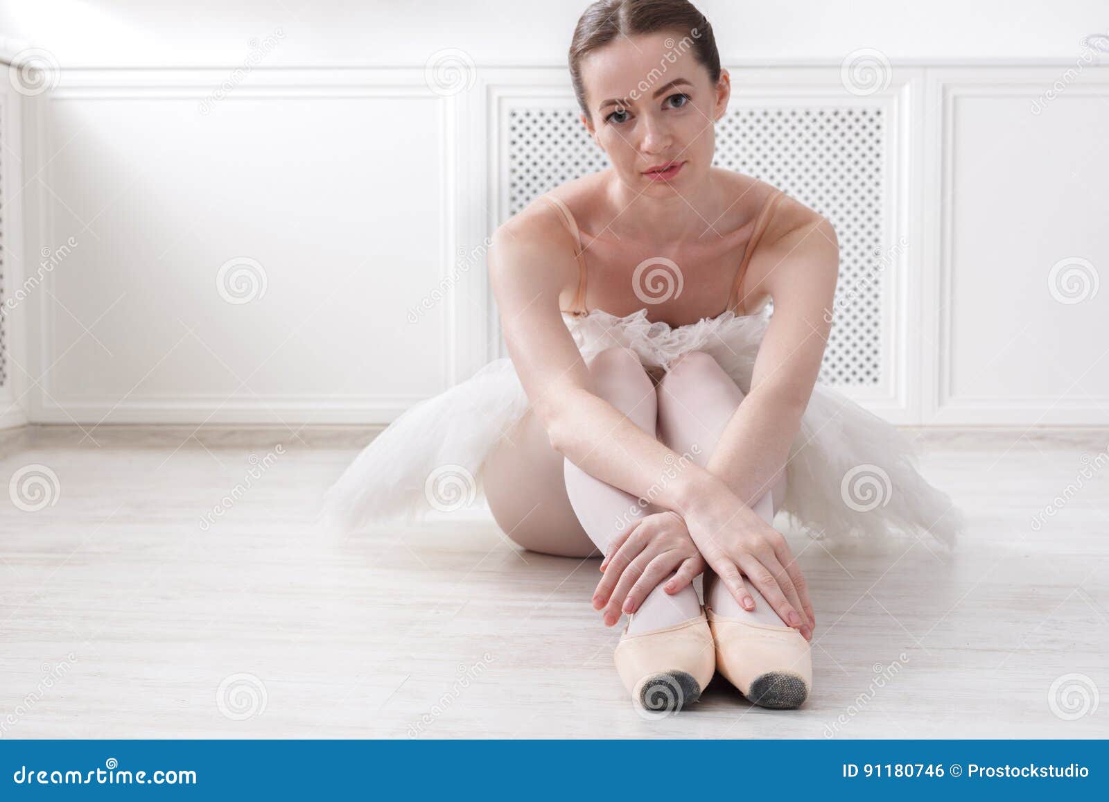 Graceful Ballerina Sit On Floor Ballet Background Stock Photo